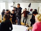 Mehrere junge Menschen stehen um einen Tisch herum.