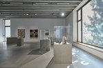 Ausstellungsobjekte jeglicher Art stehen und hängen im Ausstellungsraum. Vitrinen und Plexiglaswände stehen auf Betonsockeln. Das Licht ist gedimmt. Insgesamt herrscht ein musealer Charakter.