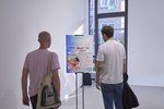 Two male visitors in T-shirts look at the information stand "Stsc" by Sanja Henning. It reads in large letters: Depression