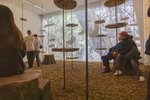 There are wood chips on the floor, and wooden panels are repeatedly attached to the bars from the ceiling.
