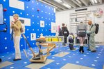 A room completely tiled in blue and white, with numerous sculptures and pictures, and lots of exhibition visitors in between.