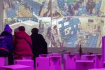 People sitting in front of a wall full of images from a surveillance camera