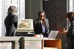 Studierende in schwarzen Anzügen nehmen vor dem Hauptgebäude der HFBK die Anmeldung von Besuchenden vor.