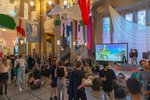 Viele Menschen in der Aulavorhalle, die reich geschmückt wurde mit bunten Stoffbahnen.