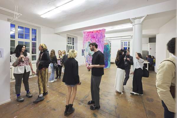 Viele junge Menschen in einem weißen Ausstellungsraum