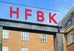 Das rote HFBK-Logo vor dem Hauptgebäude am Lerchenfeld