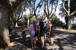 Prof. Udo A. Engel stands surrounded by five students on a shady street in Rome. He and another student are pointing upward. The other students are also looking up.