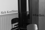 Der Schattenwurf eines Stuhls ist an der Wand zu sehen. Darüber steht der Titel des Workshops. Es ist ein schwarz/weiß Bild. 