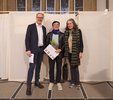 Martin Köttering, award winner Junya Fujita and Gesa Engelschall stand next to each other in the Aulavorhalle.