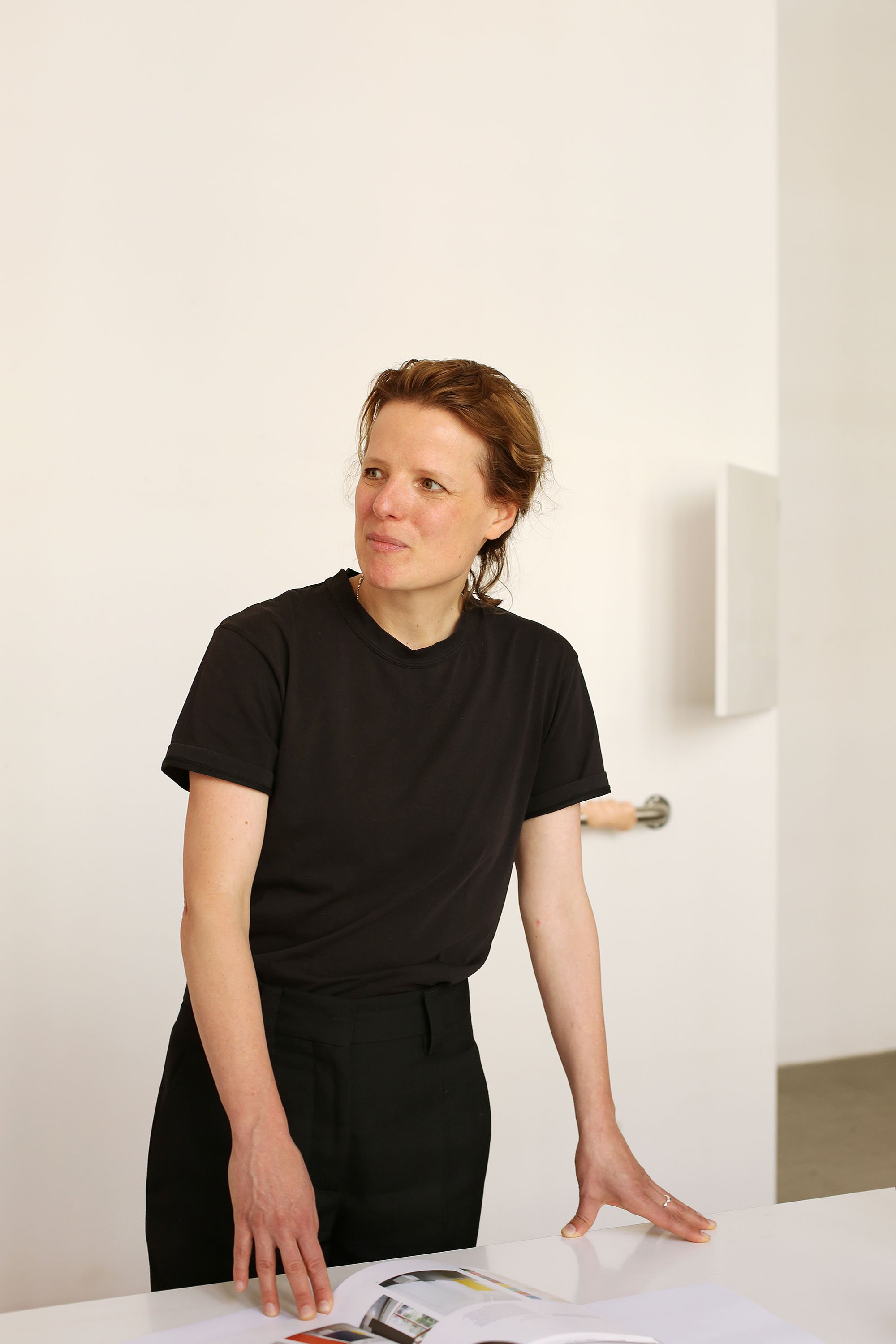 Portrait of a person  standing in a bright studio space.