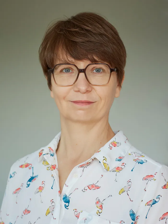 Portrait of a person against a neutral background.