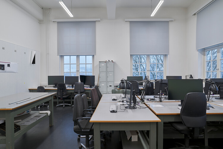 Many tables with chairs and computer monitors.
